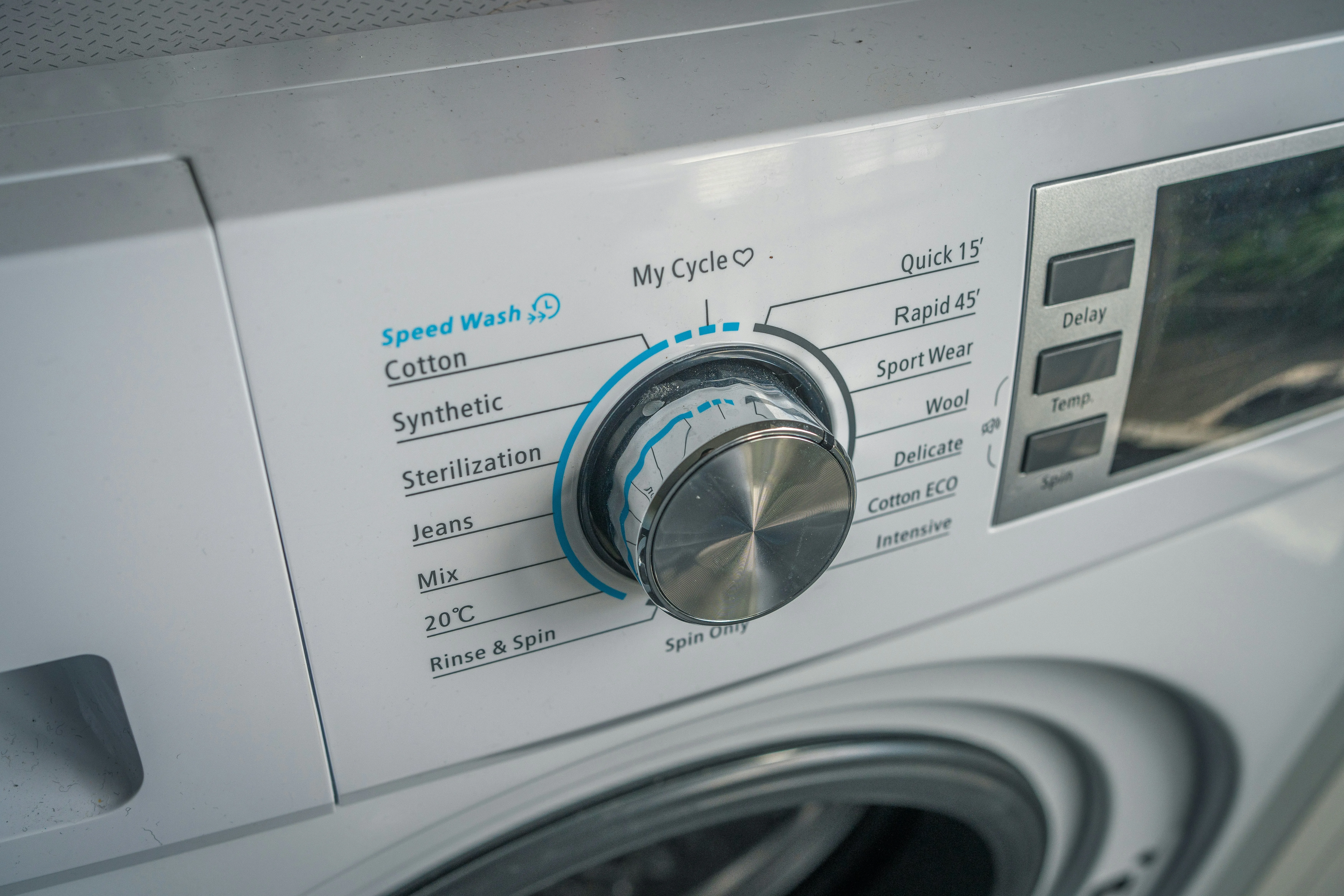 Close up of a washing machine control panel with various cycles